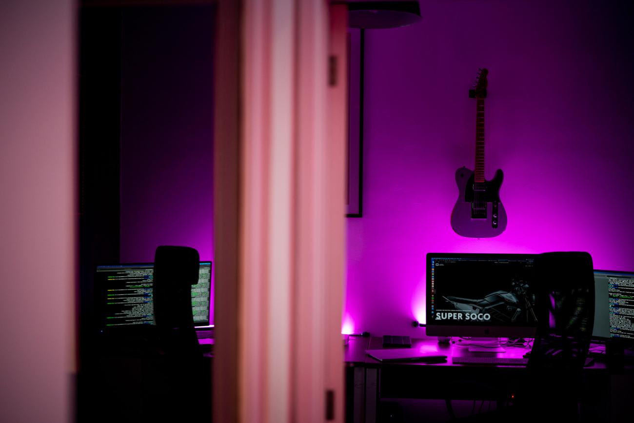 office with pink strip lighting and guitar on the wall