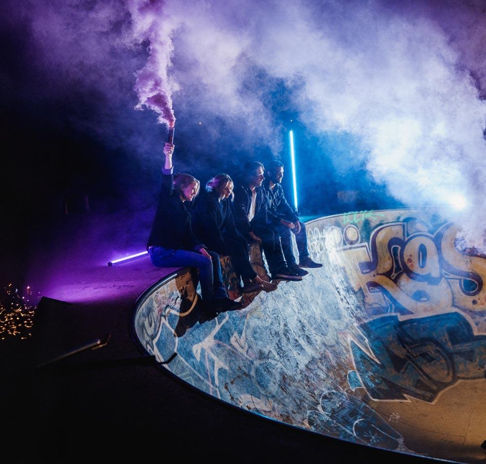 studio illicit team sat for a photo in a skatepark